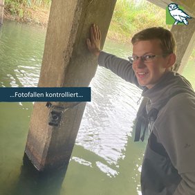Emil kontrolliert eine Fotofalle unter einer Brücke.